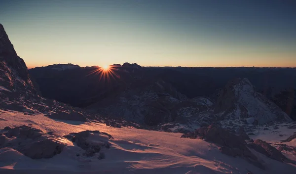 在冬天山上的史诗日落 男性的徒步旅行者等待着太阳去后山地区 在朱利安阿尔卑斯山中的亮丽风景 — 图库照片