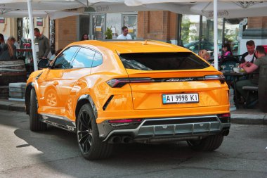 Kiev, Ukrayna - 22 Mayıs 2021: Turuncu lüks süper SUV Lamborghini Urus şehirde. Lamborghini Urus SSUV
