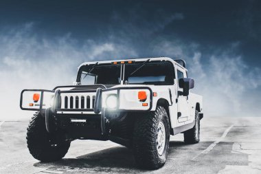 Kiev, Ukrayna - 27 Nisan 2014: Beyaz Hummer X bulutların arka planında. Farları açık askeri SUV.