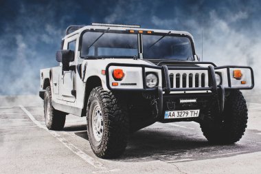 Kiev, Ukrayna - 27 Nisan 2014: Beyaz Hummer X bulutların arka planında. Farları açık askeri SUV.
