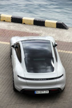Odessa, Ukrayna - 5 Eylül 2021: Porsche Taycan limanda arka planda elektrikli otomobil