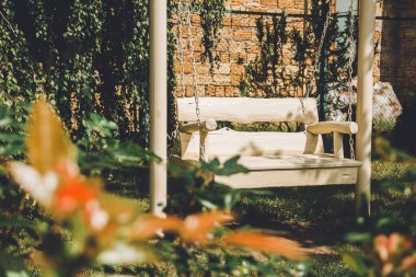 Bahçede beyaz ahşap salıncak. Romantik bir yer.