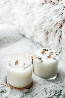 Scented candles in the interior. Interior details in milk colors. Candles in a glass