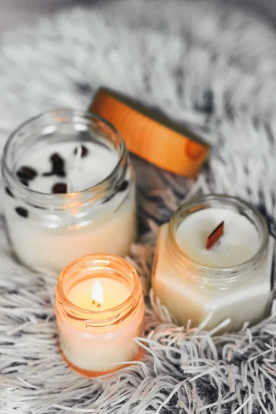 Scented candles in the interior. Interior details in milky and cold colors. Combination of warm and cold colors. Candles in a glass