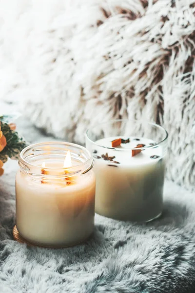 Burning candle. Scented candles in the interior. Interior details in milk colors. Candles in a glass
