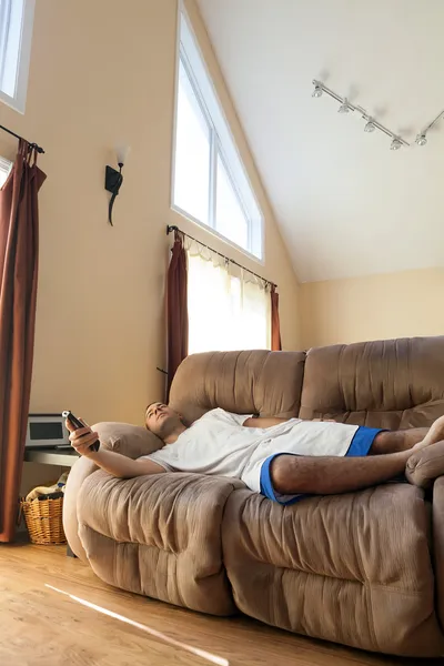 Ленивый человек лежит на диване — стоковое фото