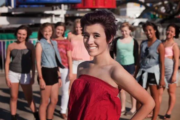 Sorridente adolescente ragazza di fronte agli amici — Foto Stock