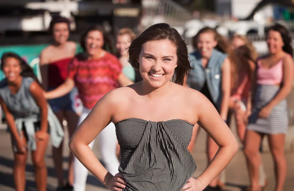 Lächelnde junge Frau mit Freunden draußen — Stockfoto