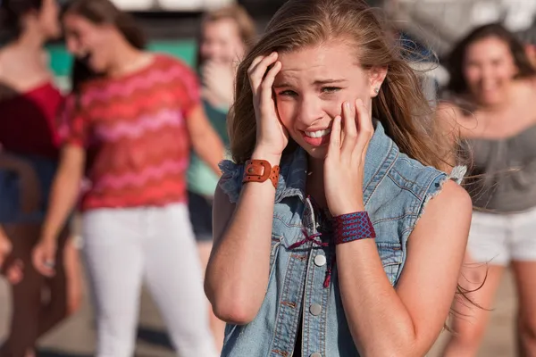 Adolescents riant à fille effrayée — Photo