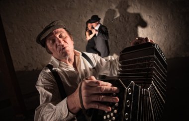 bandoneon oyuncu yakınındaki iki dansçı