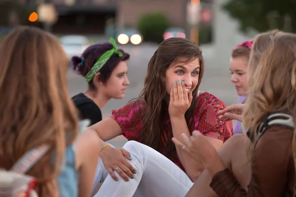 Whispering tiener vrouwelijke met vrienden — Stockfoto