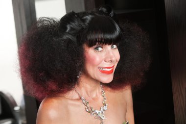 Beyaz bir kadın afro ve büyük bir gülümseme