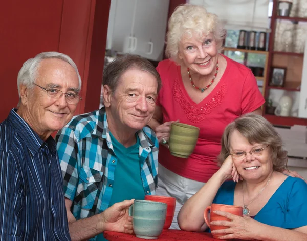 Vier lachende vrienden in bistro — Stockfoto