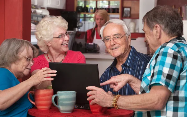 Senioren met plezier met computer in café — Stockfoto