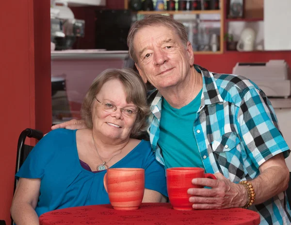 Usmíval se starší muž a žena u stolu — Stock fotografie