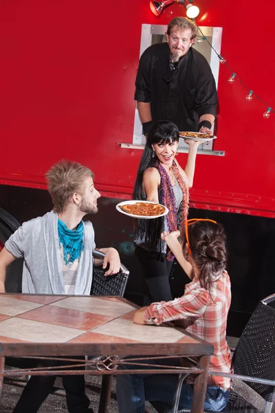 Freunde holen heiße Pizza aus LKW — Stockfoto