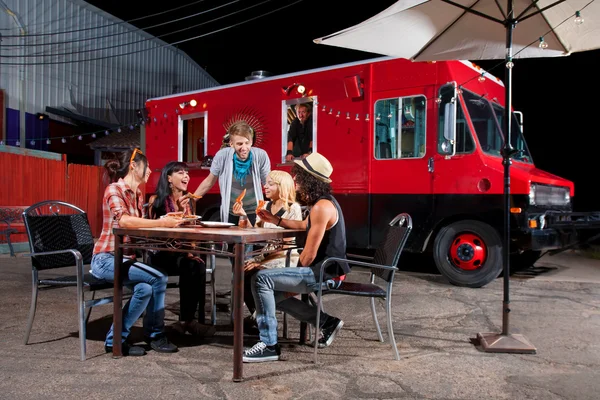 Eten van pizza in de buurt van voedsel vrachtwagen — Stockfoto