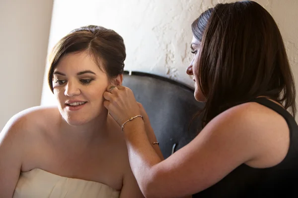 Femme aidant mariée avec boucles d'oreilles — Photo