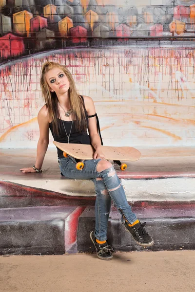 Jonge vrouw bedrijf skateboard — Stockfoto