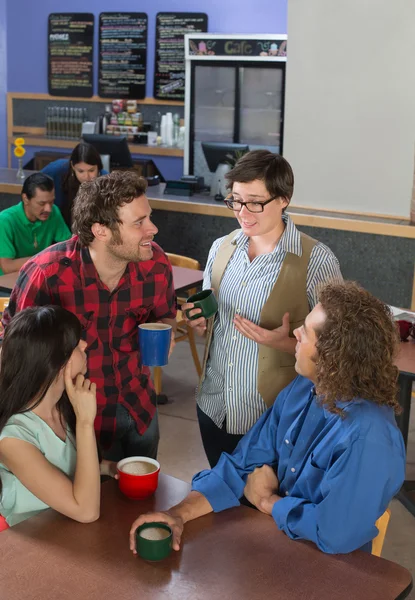 Vrouw praten met mensen in café — Stockfoto