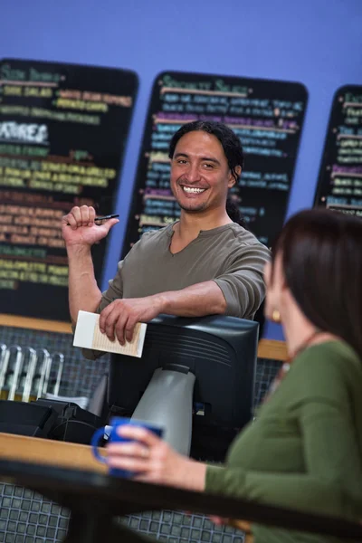 Lindo trabajador de café señalando en el menú —  Fotos de Stock