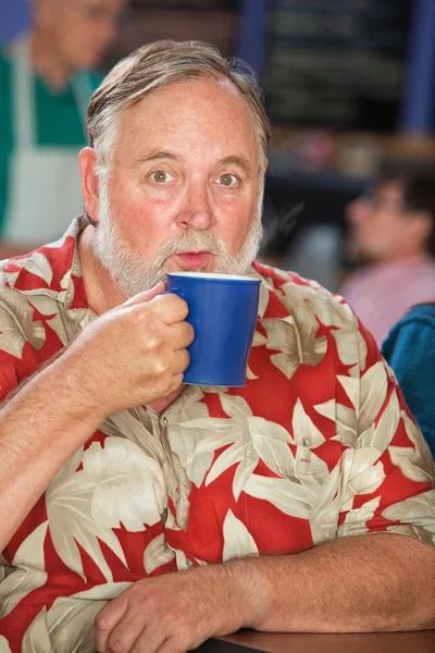 Homme soufflant sur tasse de café — Photo