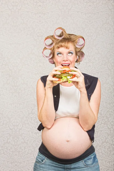 Mujer embarazada comiendo un sándwich — Foto de Stock