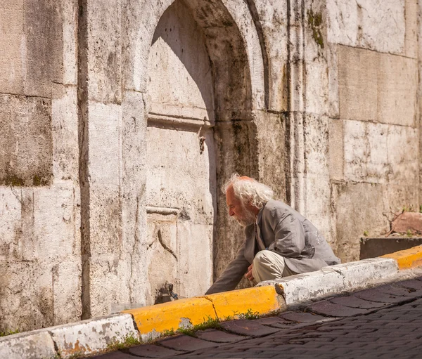 Стамбульский мужчина заливает воду в колодец — стоковое фото