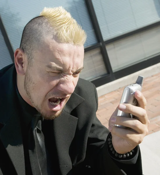 Frustrerad punk affärsman på sin mobiltelefon — Stockfoto