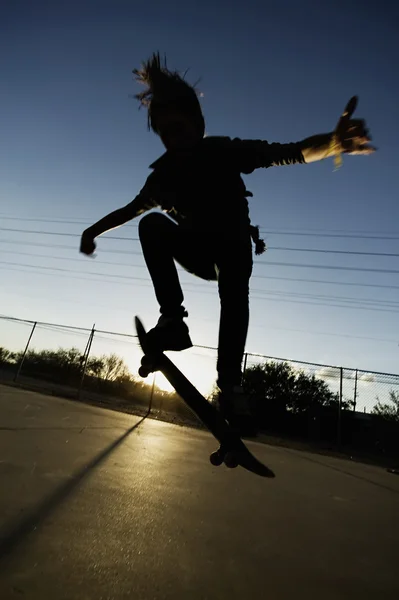 Teenage skateboardåkare i solnedgången — Stockfoto