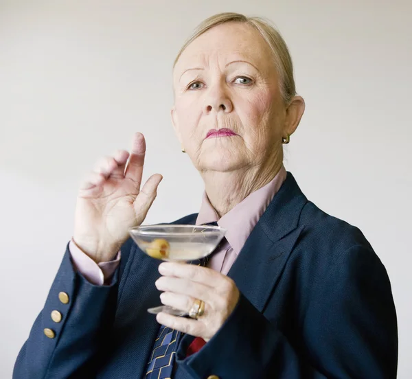 Dramatische senior vrouw met een martini — Stockfoto