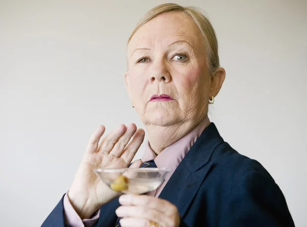 Dramatische senior vrouw met een martini — Stockfoto