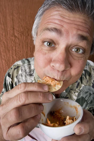 Человек ест чипсы и соус — стоковое фото
