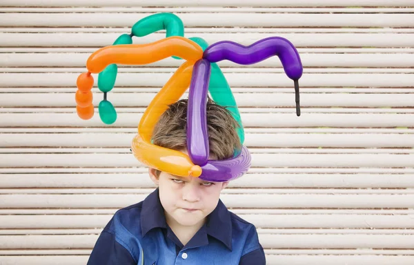 Boos jongen met een ballon hoed — Stockfoto