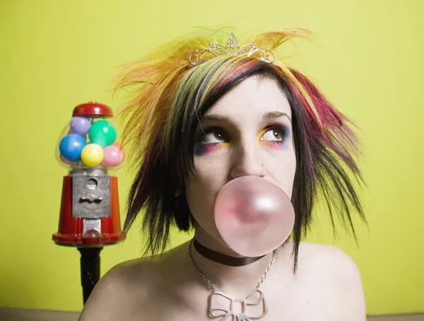 Punk Chica en frente de una pared verde que sopla una burbuja — Foto de Stock