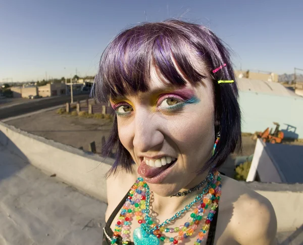 Cute young woman on a roof sticking out her tongue — Stock Photo, Image