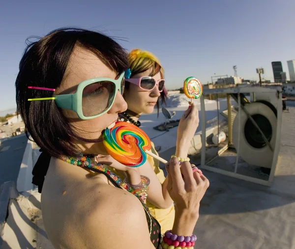 Leuke meisjes op het dak met lollies — Stockfoto