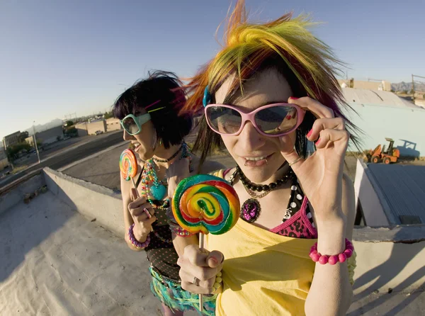 Fun girls on the roof with lollipops — Stock Photo, Image