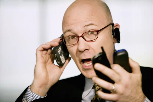 Businessman with multiple cell phones — Stock Photo, Image