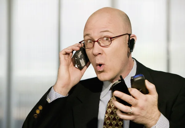 Businessman with multiple cell phones — Stock Photo, Image