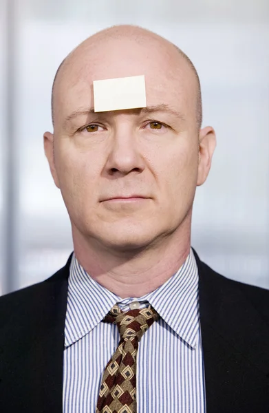 Businessman with a blank note on her forehead — Stock Photo, Image