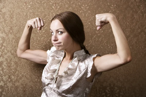 Jovem mulher flexionando seu bíceps — Fotografia de Stock