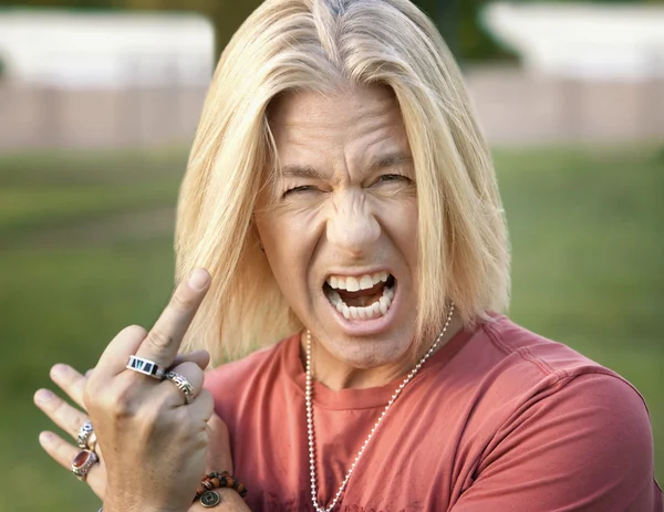 Rock "n" Roll-Typ mit ausgestrecktem Mittelfinger — Stockfoto