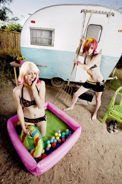 Woman attempts to puncture her friends playpool — Stock Photo, Image