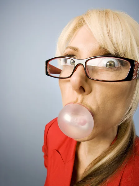 Vrouw in het rood waait een zeepbel — Stockfoto