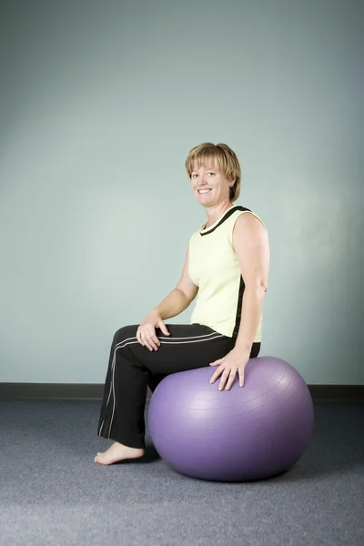 Femme assise sur un ballon d'exercice — Photo