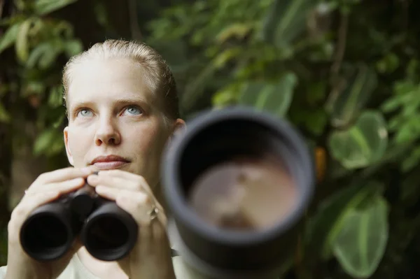 Hübsche Frau mit Fernglas im Regenwald — Stockfoto