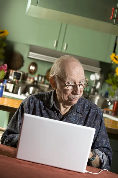 Senior man met een laptopcomputer — Stockfoto