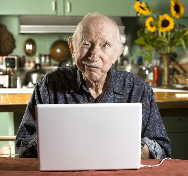 Senior man met een laptopcomputer — Stockfoto