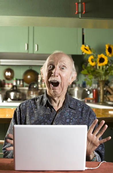 Homem Senior chocado com um computador portátil — Fotografia de Stock